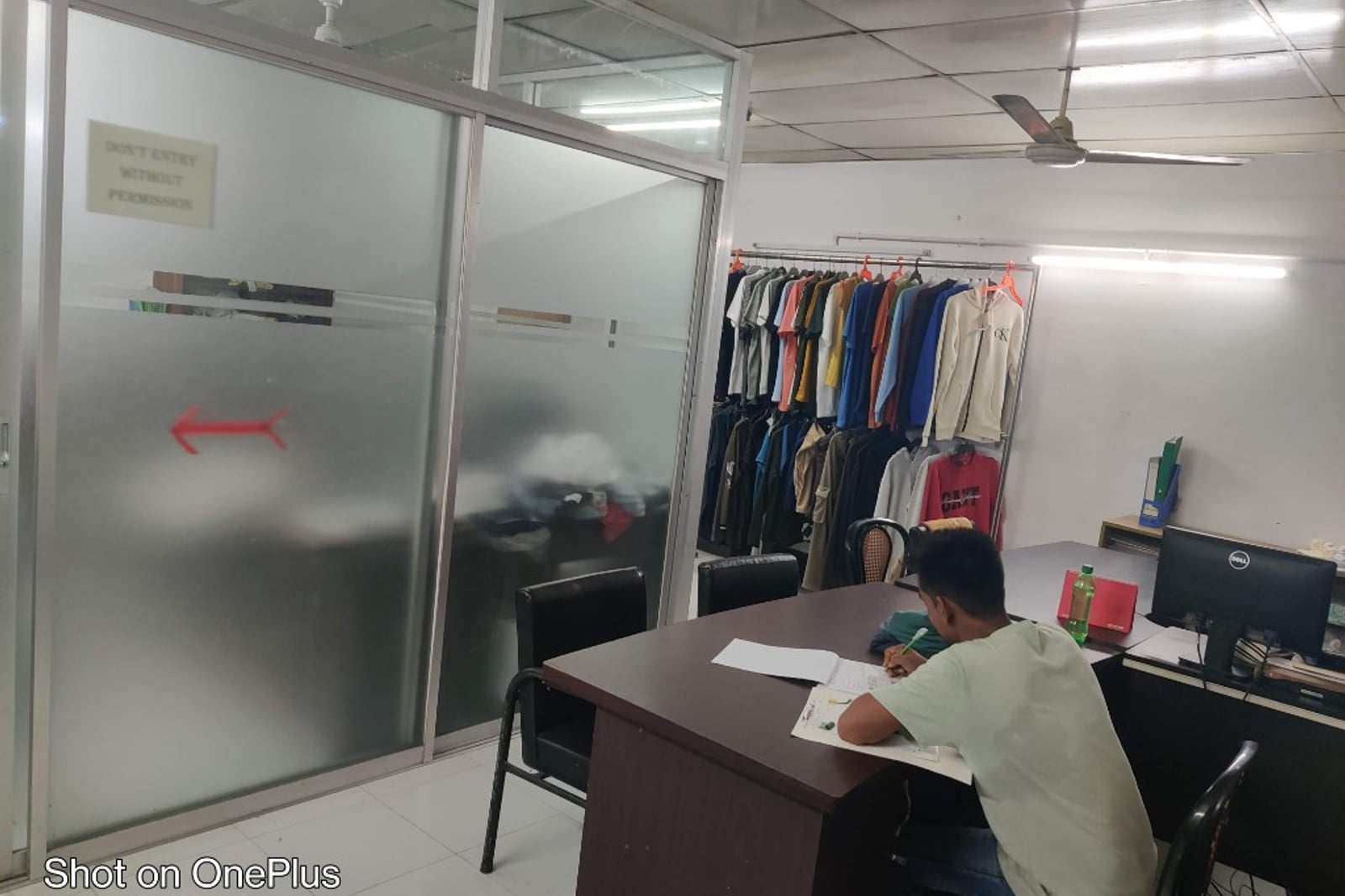 H & MR Supply Chain merchandising office — sample garments on rack and order paperwork